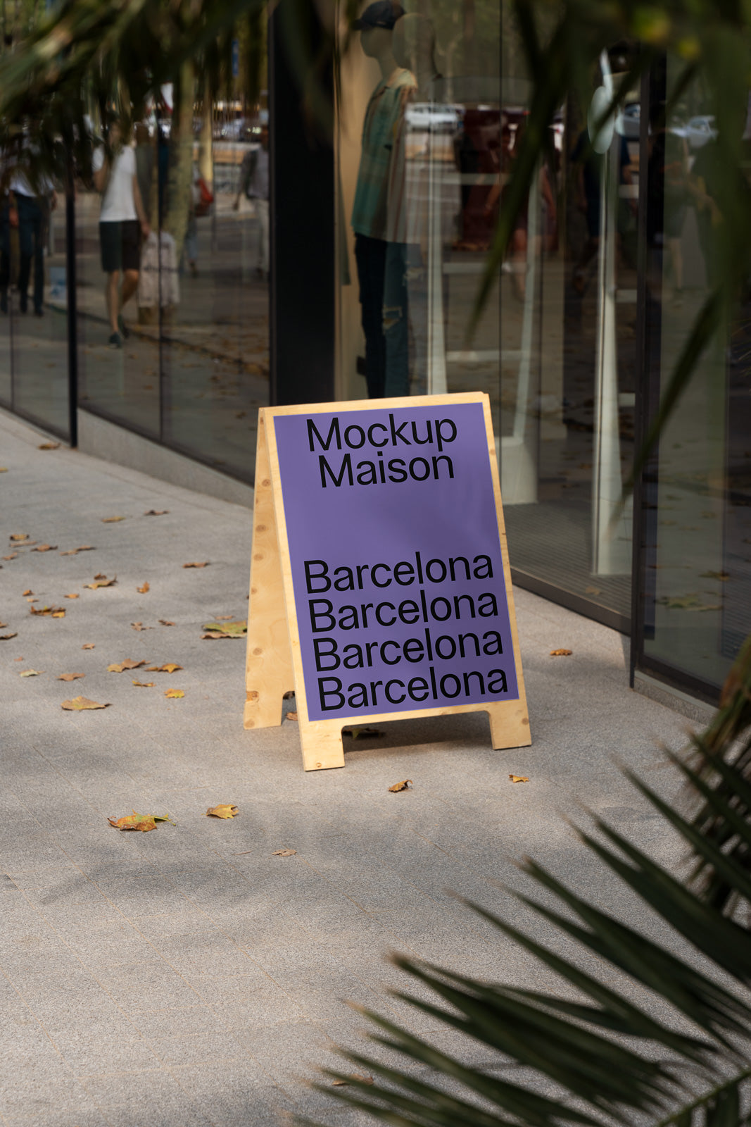 PSD mockup of a wooden sandwich board outside a storefront displaying "Mockup Maison" and multiple mentions of "Barcelona" in black text on a purple background.