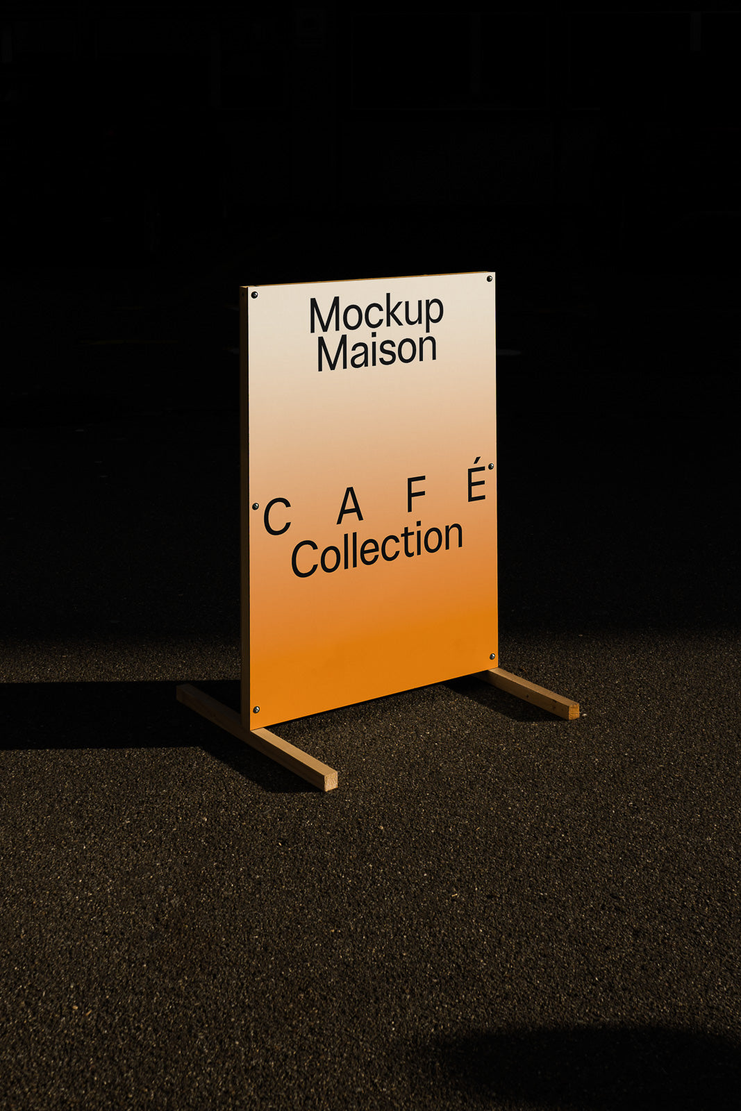 PSD mockup of an orange and white café sign reading "Mockup Maison CAFÉ Collection" displayed on a wooden stand against a dark background.