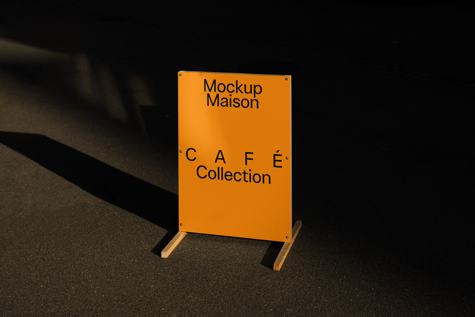 PSD mockup of a freestanding rectangular yellow sign titled "Mockup Maison CAFE Collection" positioned on a dark street surface.