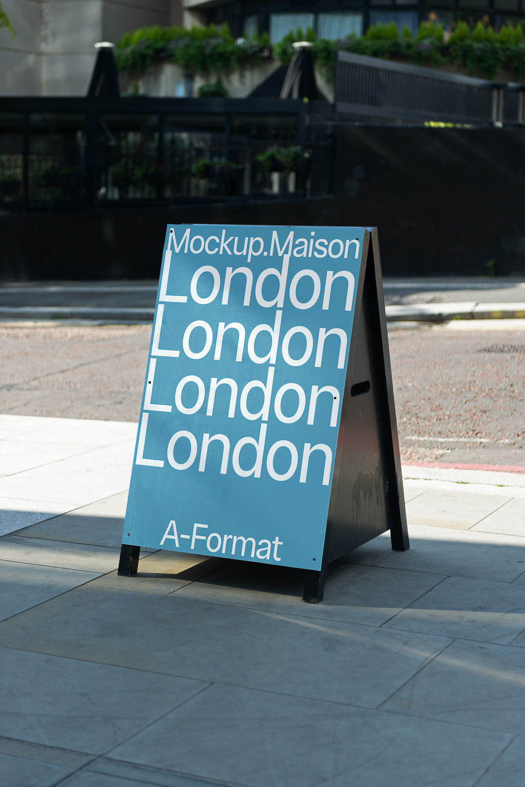 PSD mockup of a sidewalk sign displaying the text "Mockup.Maison London London London London" on a blue background with "A-Format" at the bottom.