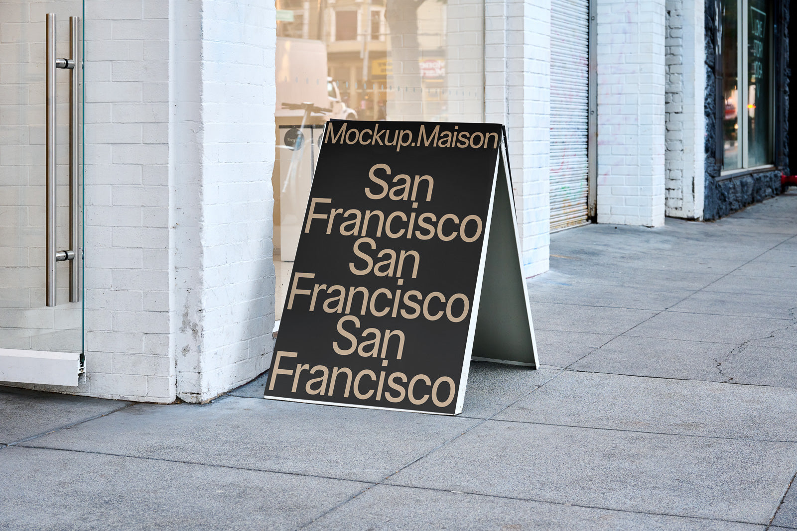 PSD mockup of a sidewalk A-frame sign with "San Francisco" text repeated in large, bold font on a reflective black background, positioned outside a storefront.