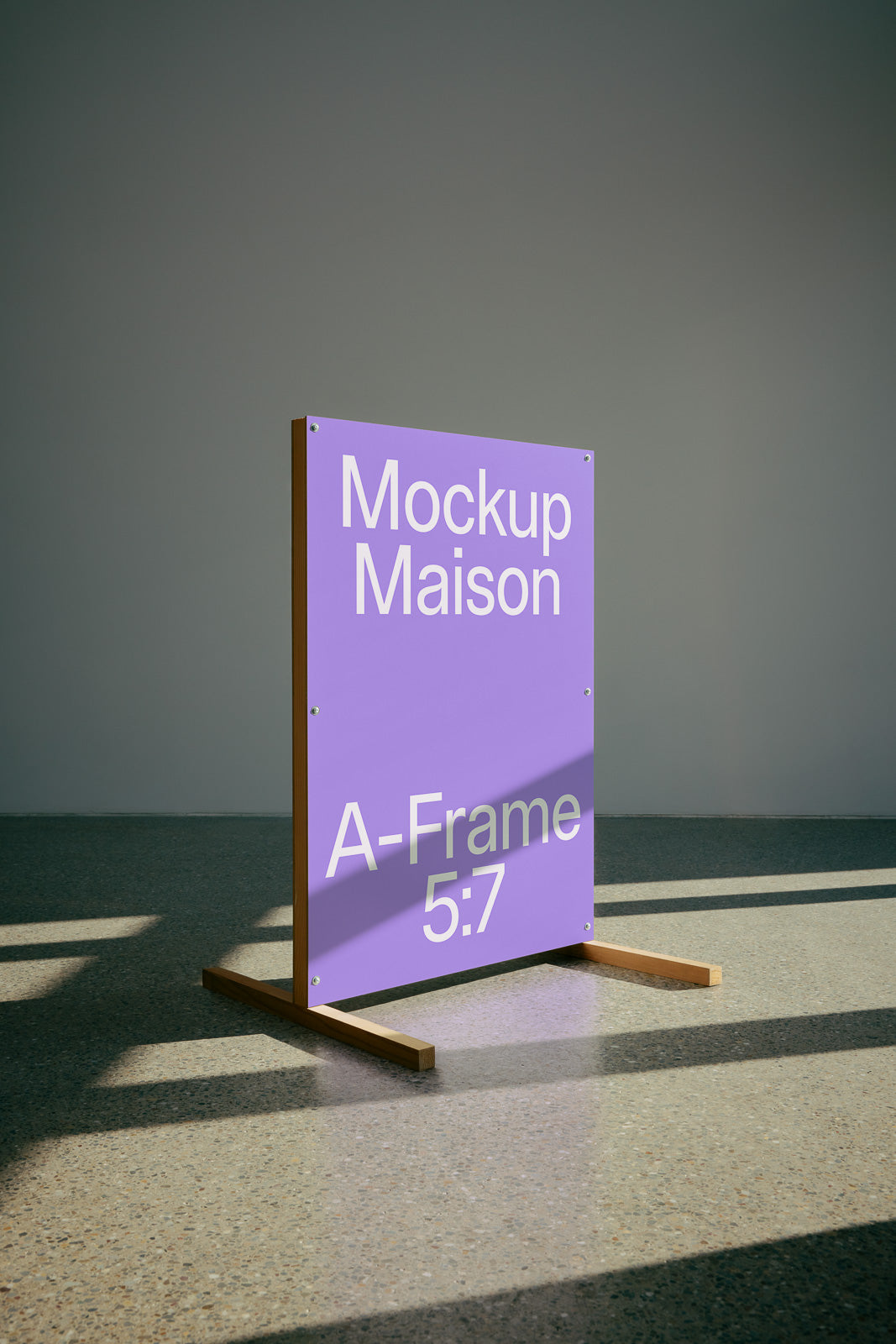 PSD mockup of a freestanding A-frame sign with a purple background displaying text "Mockup Maison A-Frame 5:7" against a simple floor backdrop.