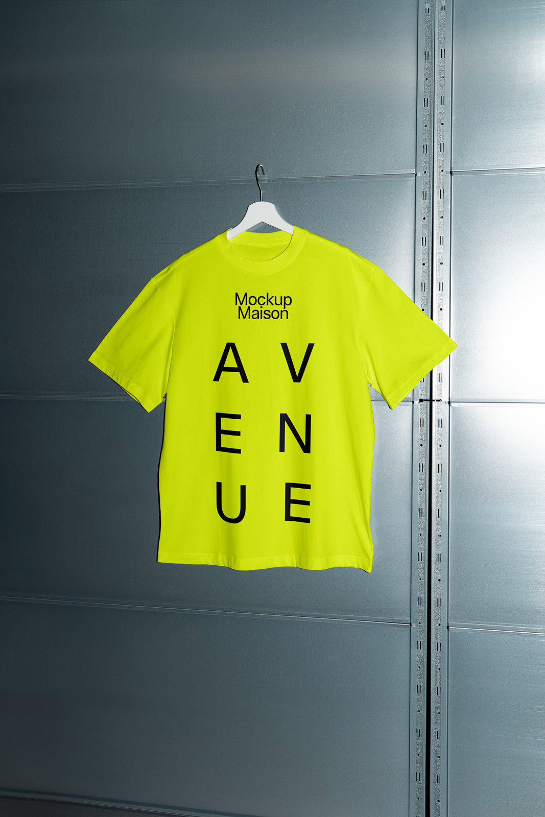 PSD mockup of a neon yellow T-shirt hanging on a white hanger against a metallic textured background. The shirt features bold black text reading "Avenue."