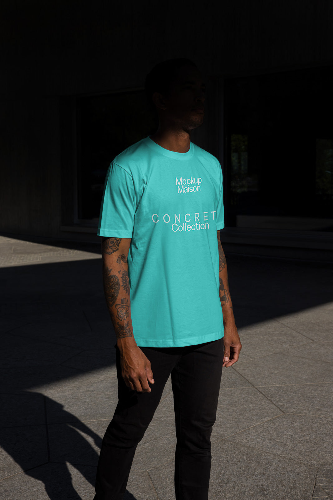 PSD mockup of a person wearing a turquoise t-shirt with "Mockup Maison CONCRETE Collection" printed on the front.