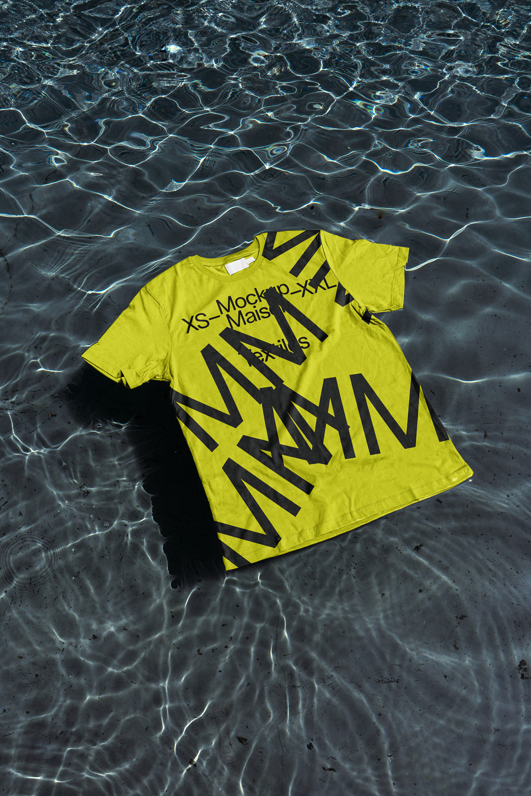PSD mockup of a bright yellow T-shirt with bold black typography floating on clear, rippling water, showcasing the design's vivid contrast and texture.
