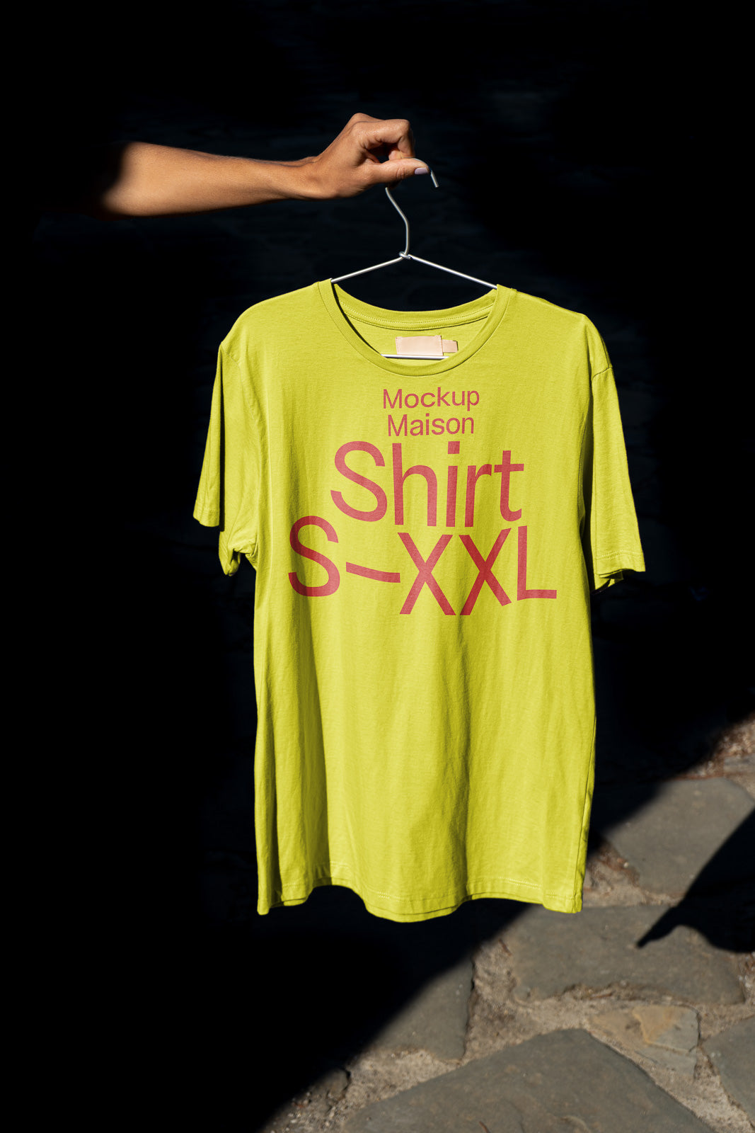 PSD mockup of a lime green T-shirt on a hanger held by a hand, featuring text "Mockup Maison Shirt S-XXL" in red.