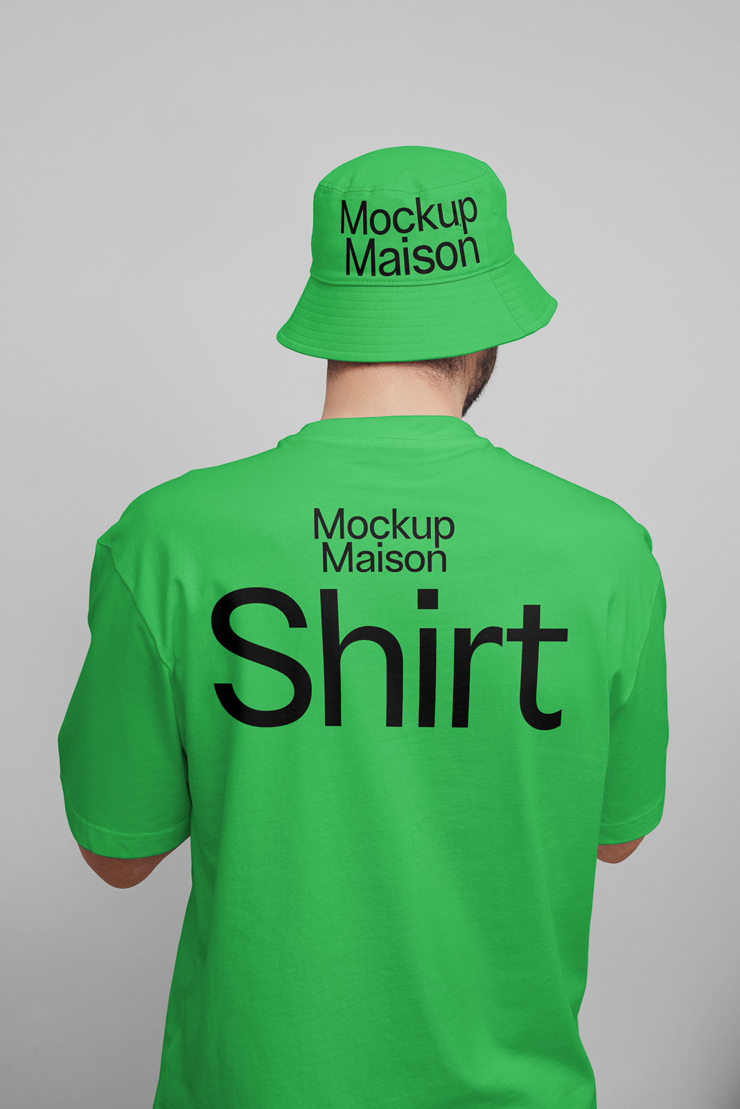 PSD mockup of a person wearing a bright green t-shirt and matching bucket hat, both displaying the text "Mockup Maison" on the back.