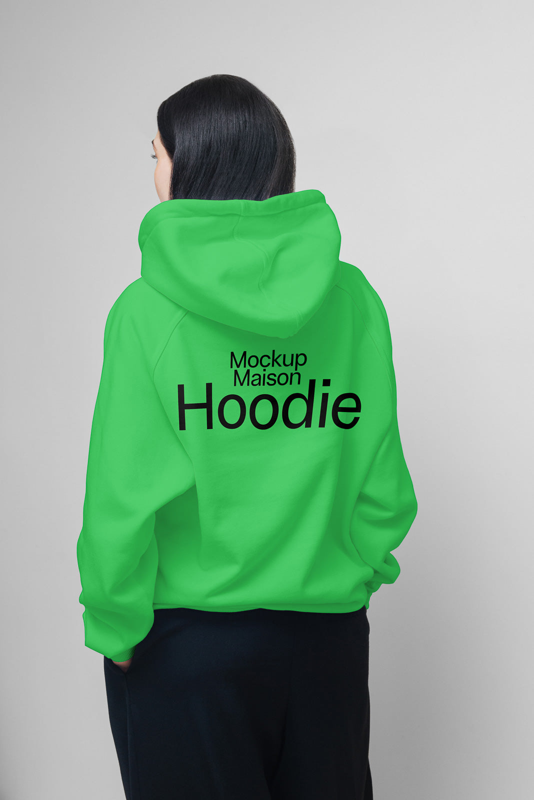 PSD mockup of a person wearing a green hoodie with "Mockup Maison Hoodie" text on the back, showing the garment's design and fit from behind.