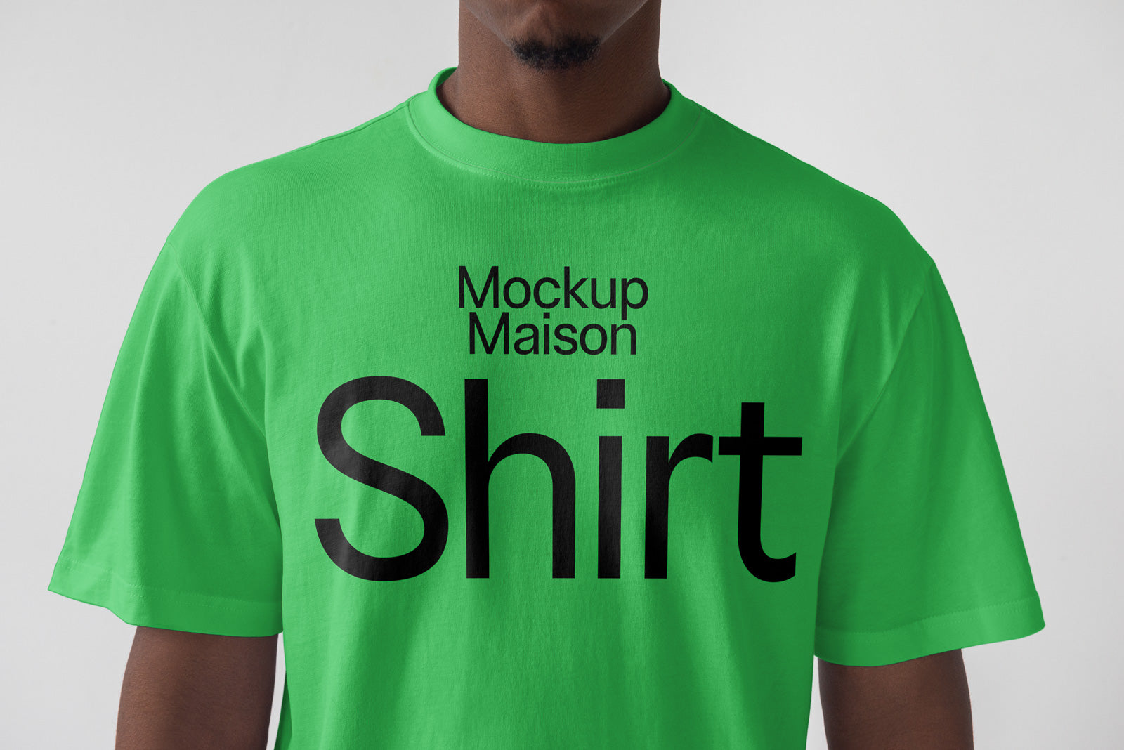 PSD mockup of a green T-shirt with the words "Mockup Maison Shirt" printed in large black letters on the front.