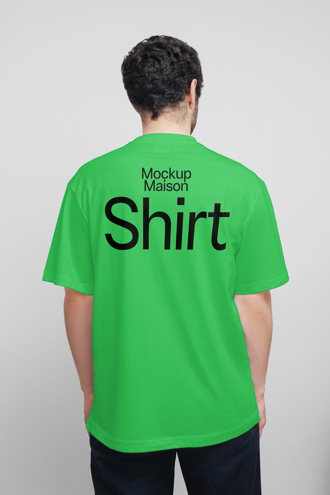 PSD mockup of a person wearing a green T-shirt with the text "Mockup Maison Shirt" on the back, viewed from behind.