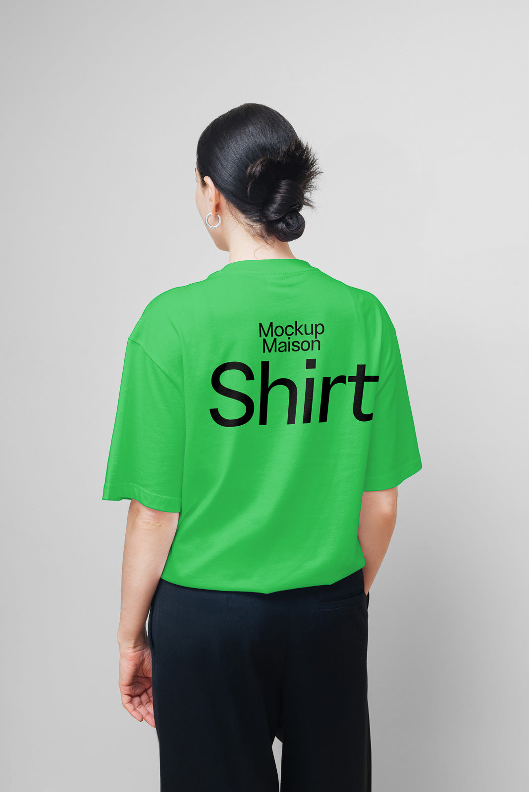 PSD mockup of a person wearing a bright green shirt with "Mockup Maison Shirt" printed in bold black text on the back, against a plain background.