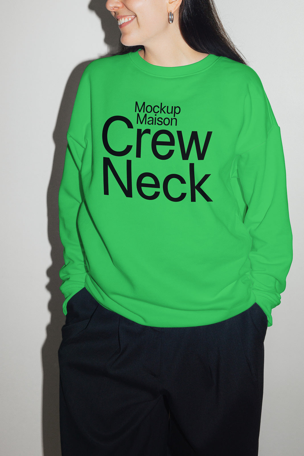 PSD mockup of a vibrant green crew neck sweatshirt featuring bold black text reading "Mockup Maison Crew Neck" worn by a person standing against a plain background.
