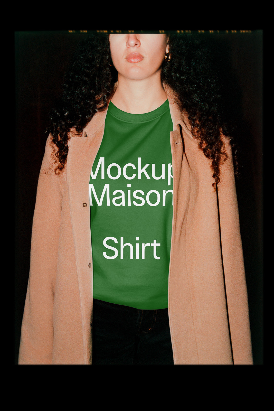 PSD mockup of a green shirt with the text "Mockup Maison Shirt" being worn under a beige coat, featuring a partial view of the wearer.