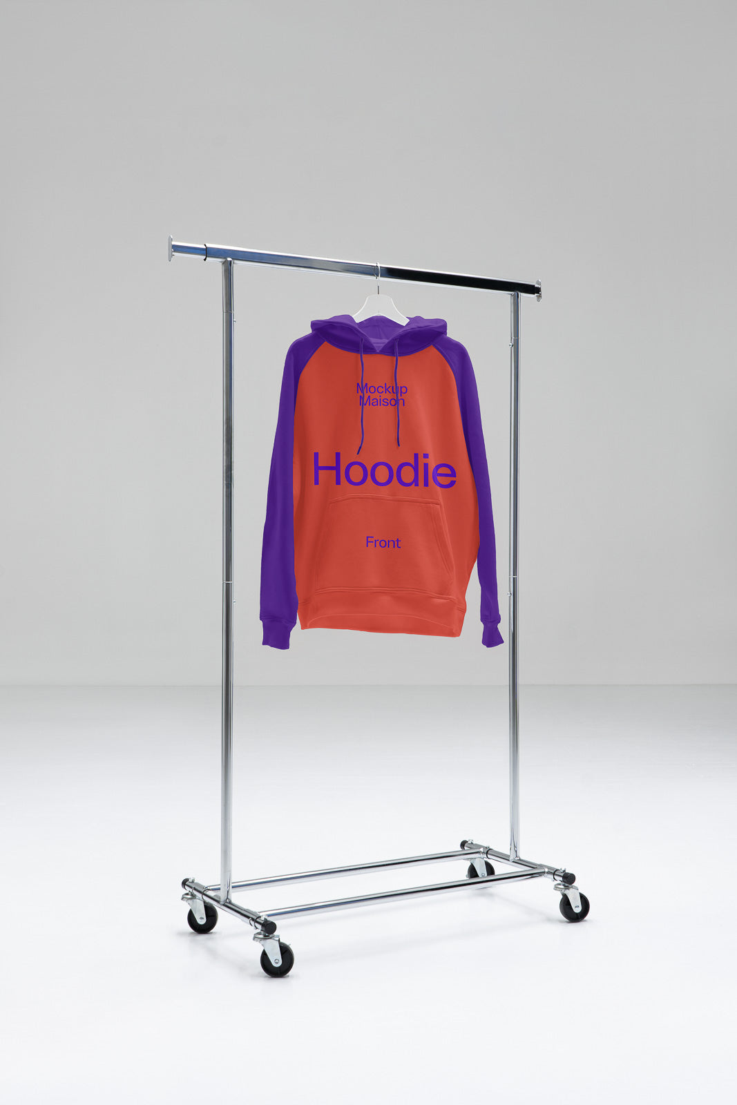 PSD mockup of a hoodie with orange front and purple sleeves hanging on a clothing rack in a minimalistic studio setting.