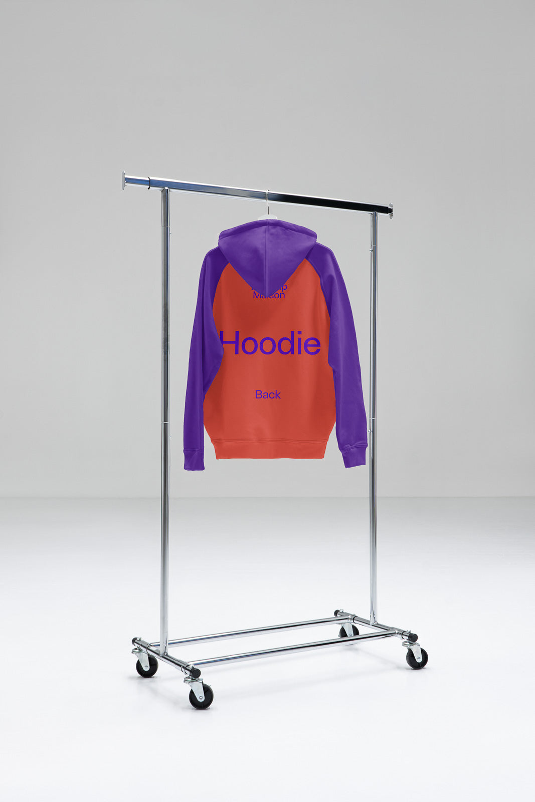 PSD mockup of a hoodie with purple sleeves and a red body, displayed on a clothing rack in a minimalist setting.