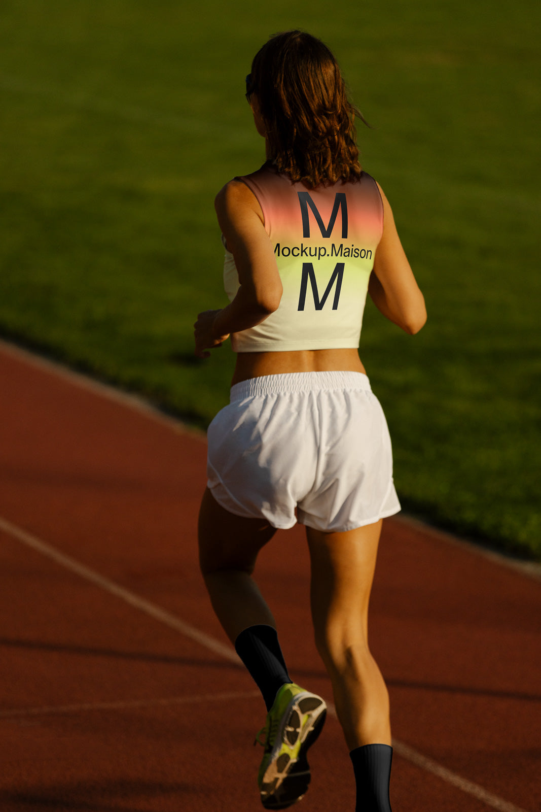 PSD mockup of a person jogging on a track, wearing a tank top with a "Mockup.Maison" design, green field in the background.