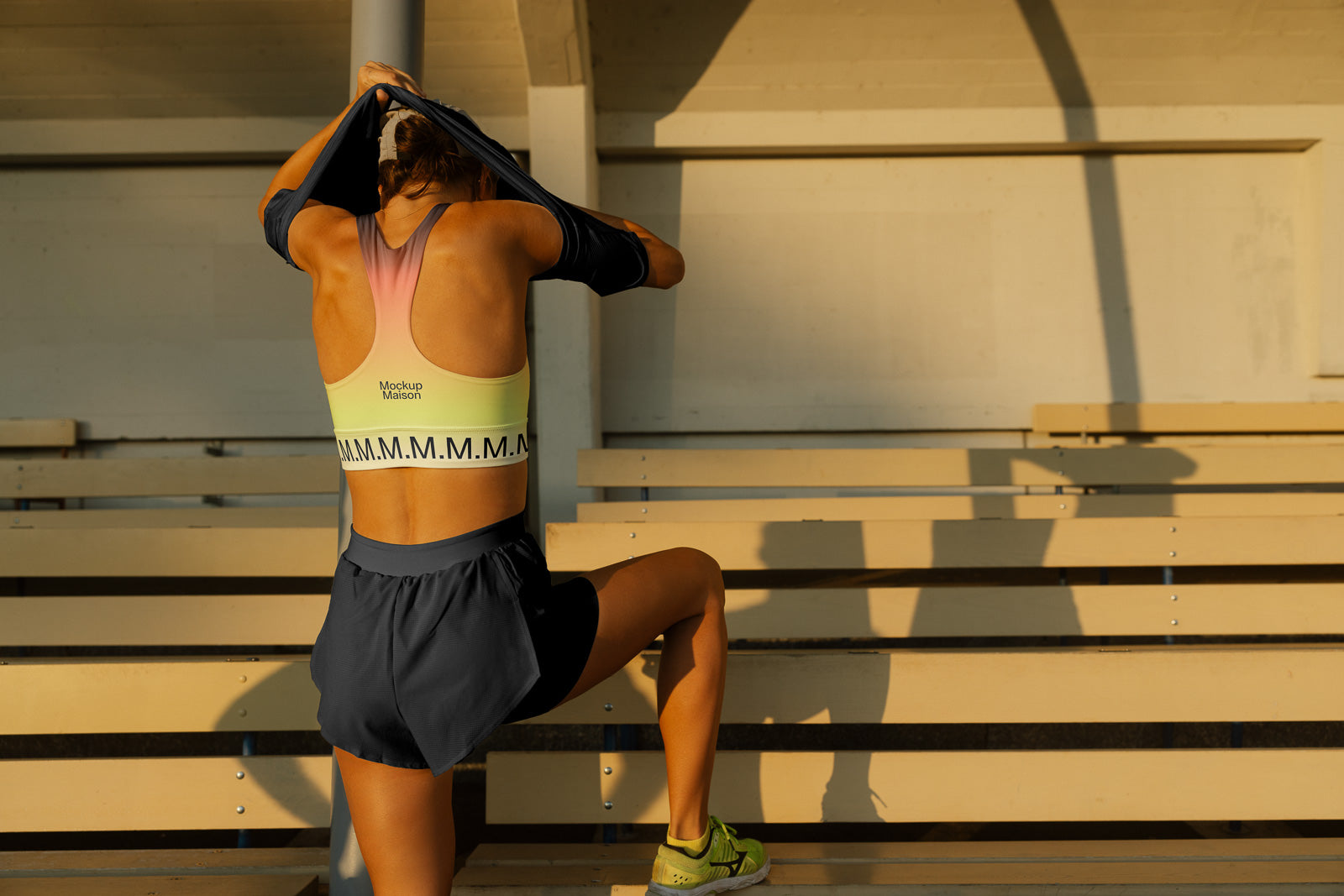 PSD mockup of a person stretching on bleachers, wearing sportswear with customizable branding on the back, under warm natural light.