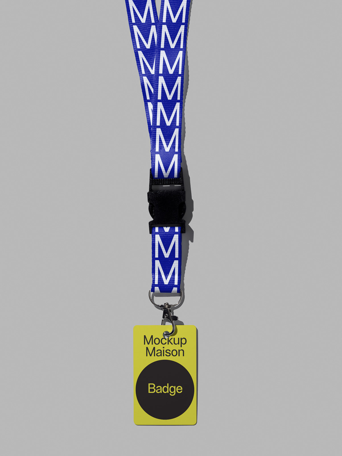 PSD mockup of a lanyard with repeating white "M" pattern on blue fabric, attached to a yellow badge labeled "Mockup Maison Badge" on gray background.