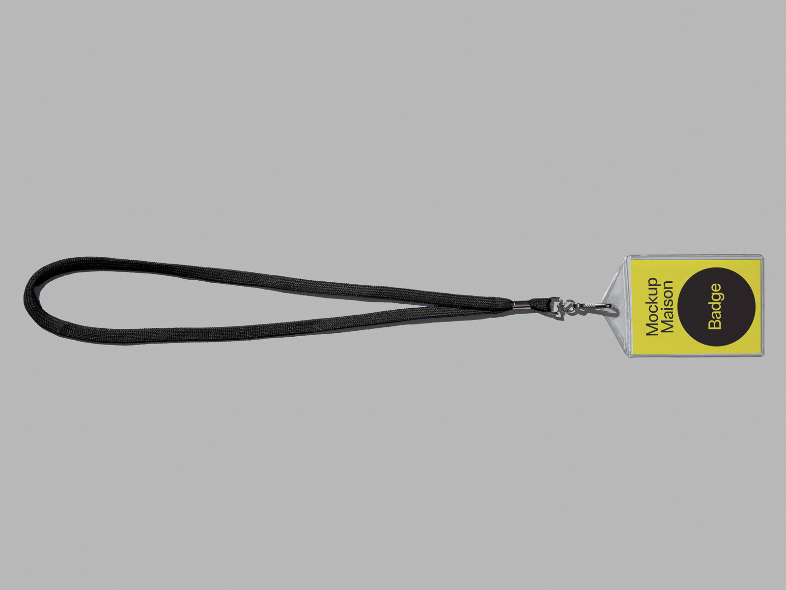 PSD mockup of a black lanyard attached to a clear badge holder with a yellow insert displaying "Mockup Maison Badge" on a gray background.
