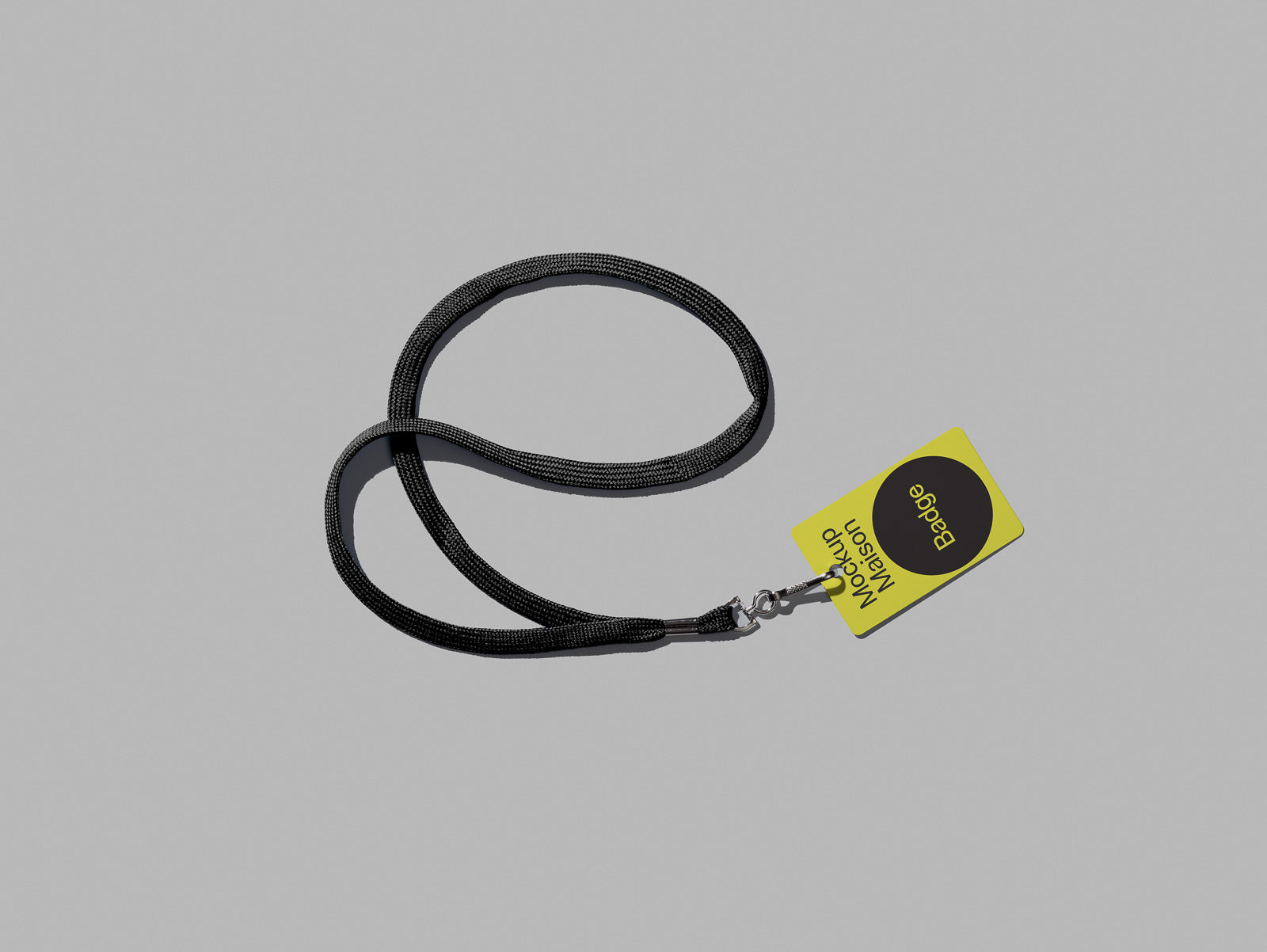PSD mockup of a black lanyard with an attached yellow badge featuring text and a circular black logo design on a gray background.