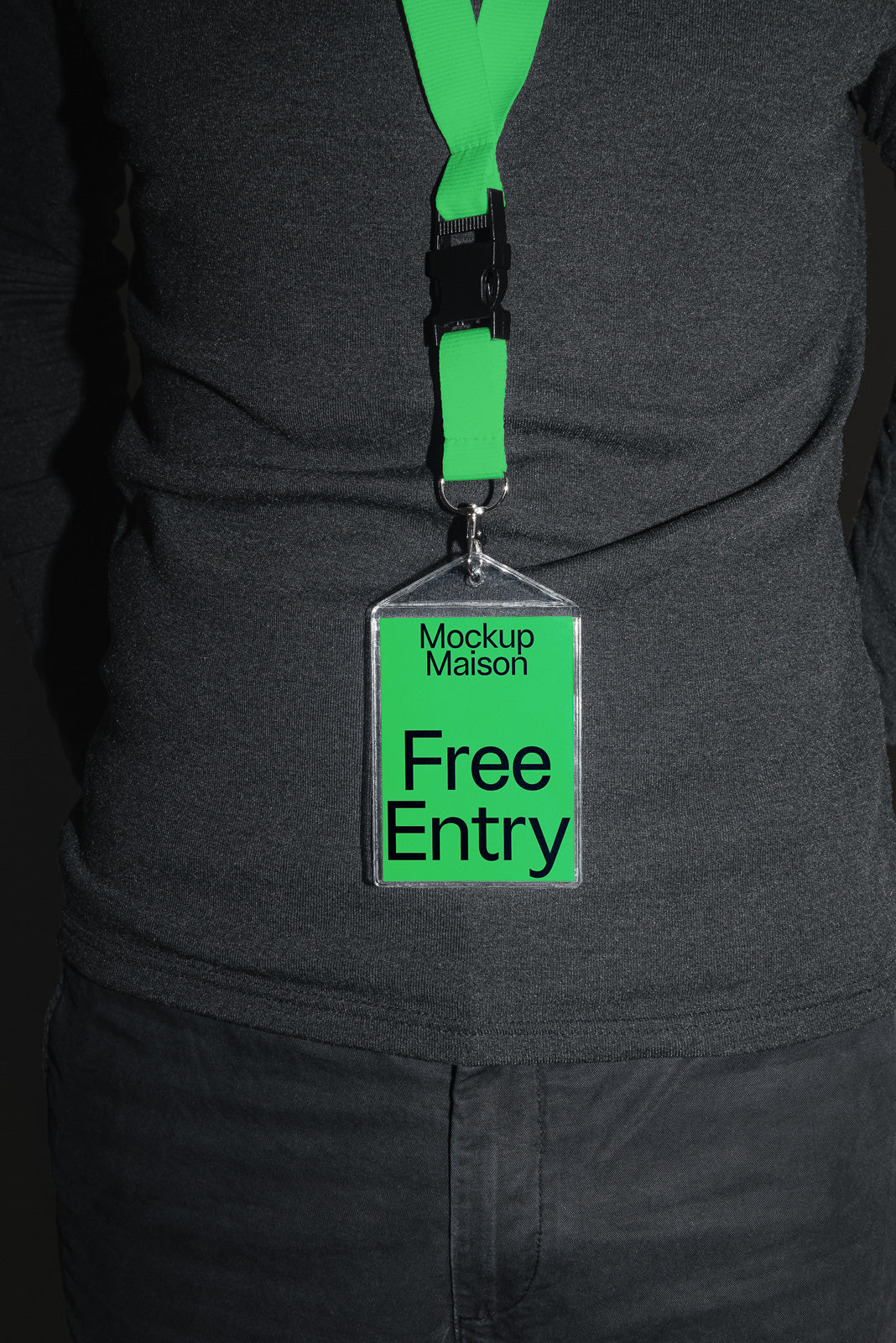 PSD mockup of a black-clad person wearing a green lanyard with a badge reading "Mockup Maison Free Entry."