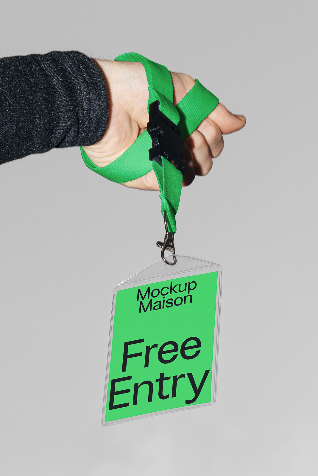 PSD mockup of a hand holding a green lanyard attached to a plastic badge displaying "Free Entry" in bold black text.