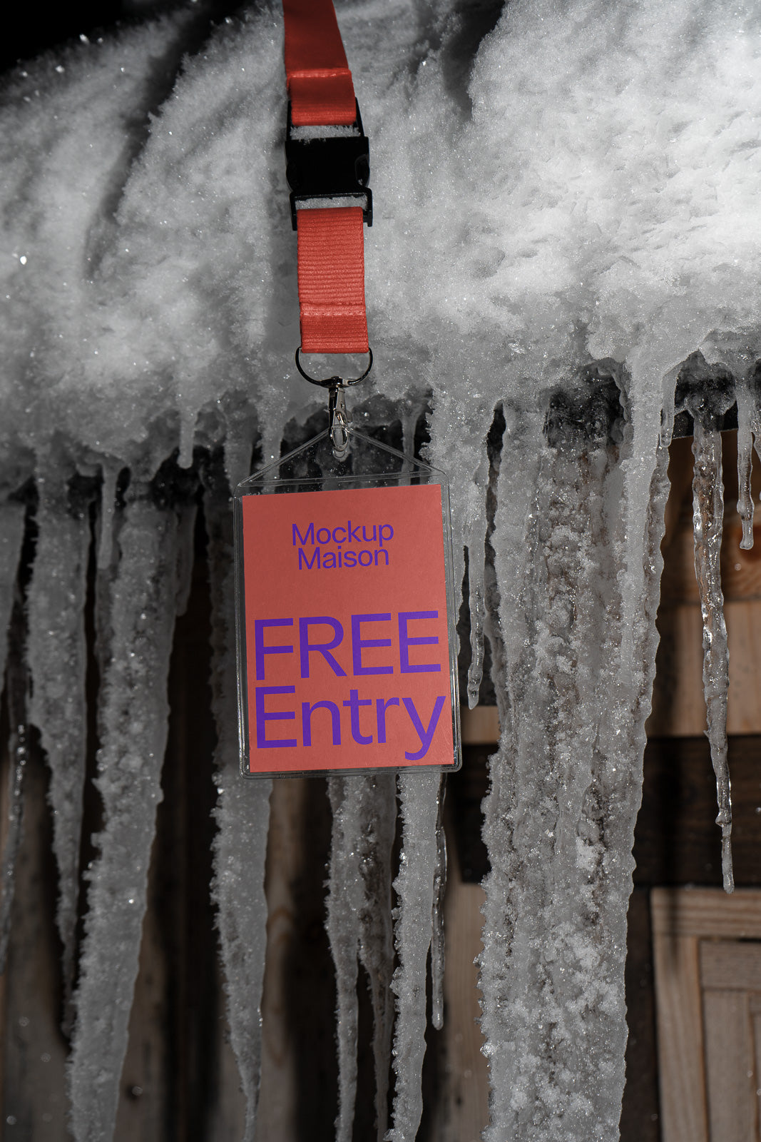 PSD mockup of a plastic name tag with "Free Entry" text on a red card, hanging from a red lanyard against a backdrop of icicles.
