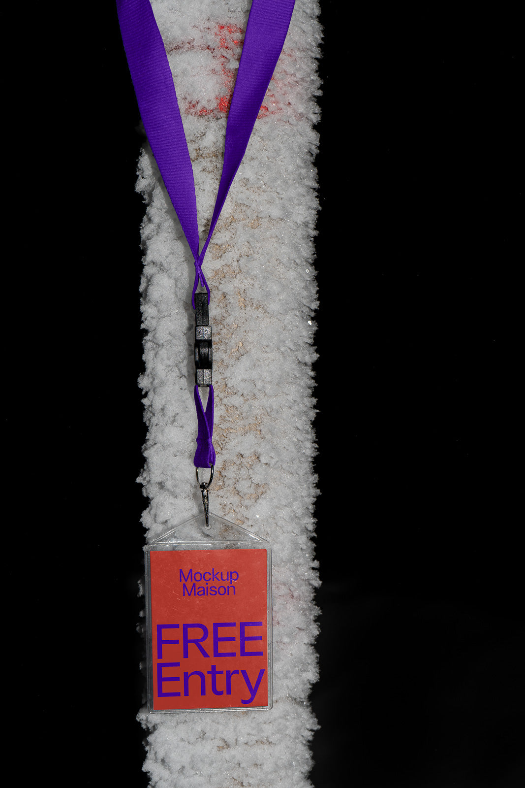 PSD mockup of a red badge with "Mockup Maison FREE Entry" text hanging on a purple lanyard against a textured snow-covered branch on a dark background.