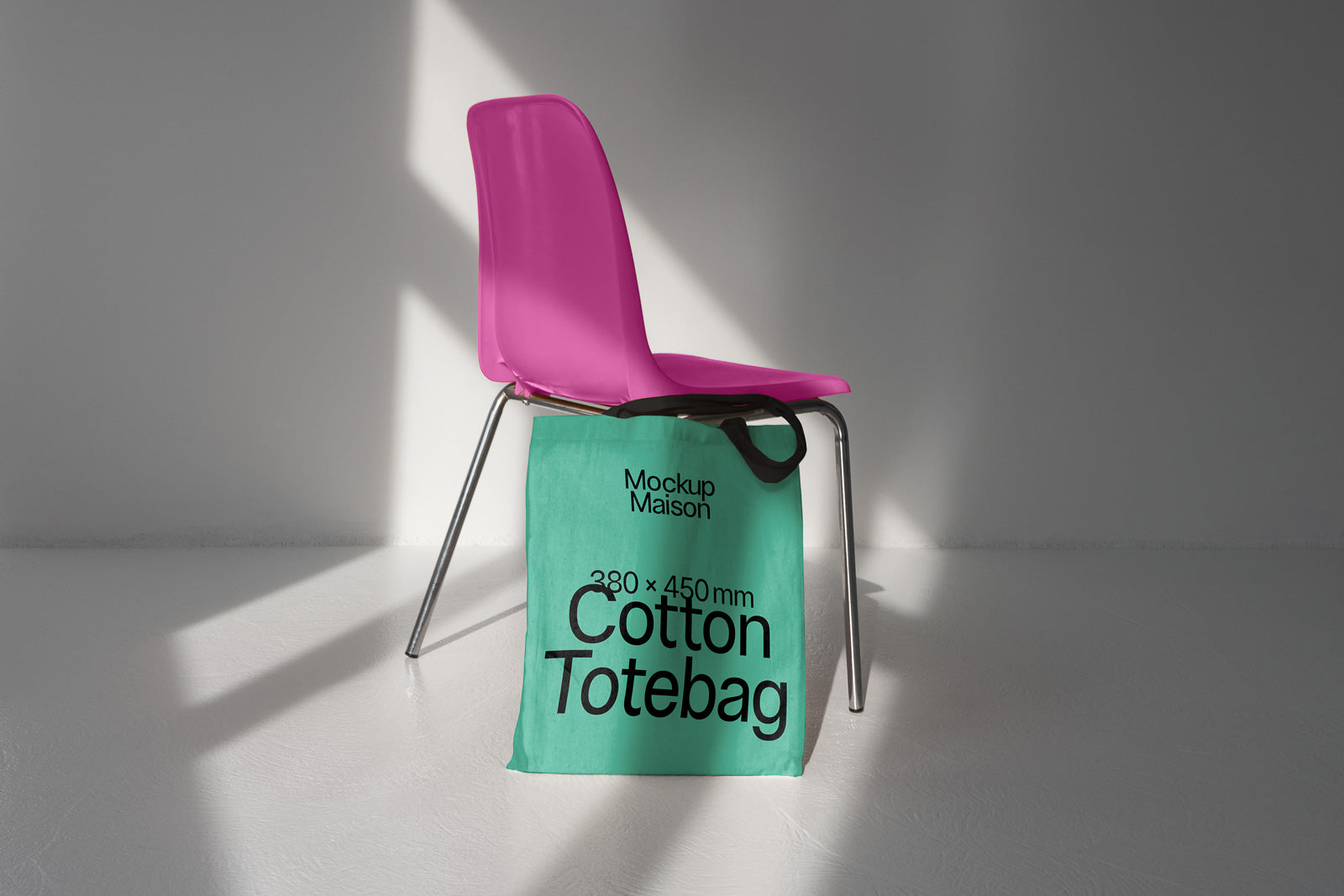 PSD mockup of a pink chair with a light green cotton tote bag labeled "Mockup Maison" and "380 x 450 mm" draped over the seat in a brightly lit room.