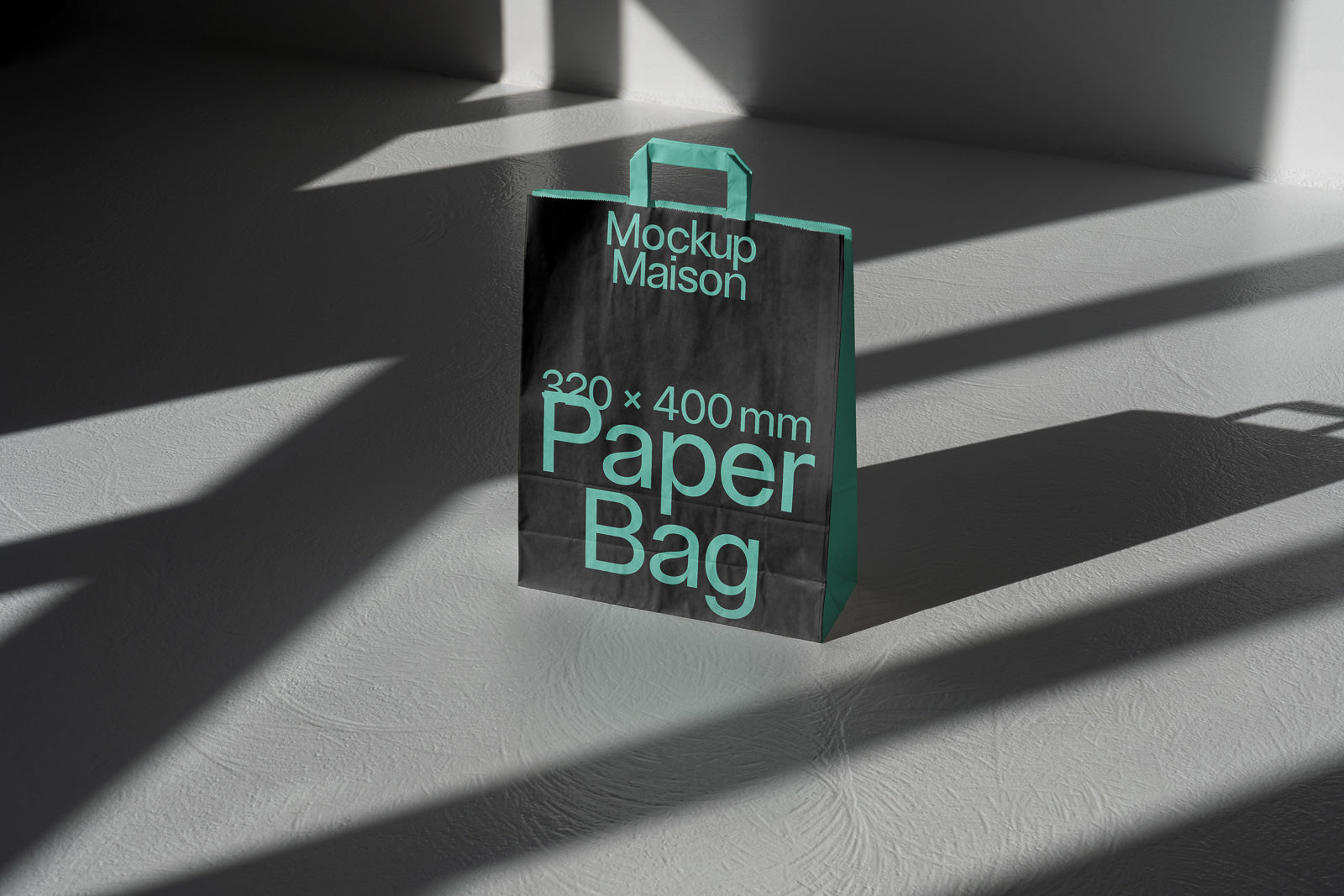 PSD mockup of a black paper bag with turquoise handles and text, placed in sunlight, displaying dimensions 320x400 mm and the phrase "Mockup Maison."
