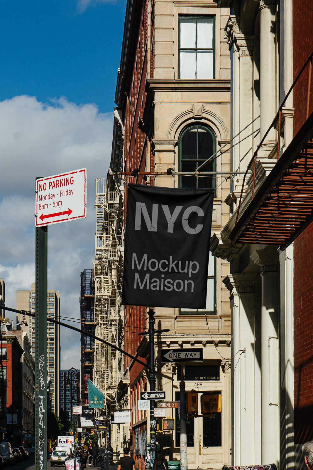 PSD mockup of a black flag with "NYC Mockup Maison" text, displayed on a brick building in a busy city street scene.