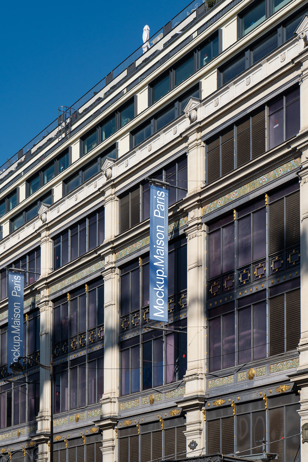 PSD mockup of a classic building facade with banners displaying "Mockup Maison Paris," showcasing architectural details against a clear blue sky.