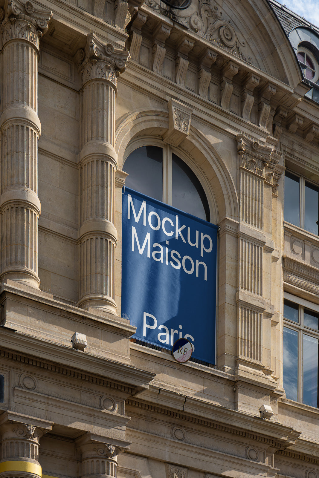 PSD mockup of a blue banner with “Mockup Maison Paris” text hanging on the facade of an ornate stone building.