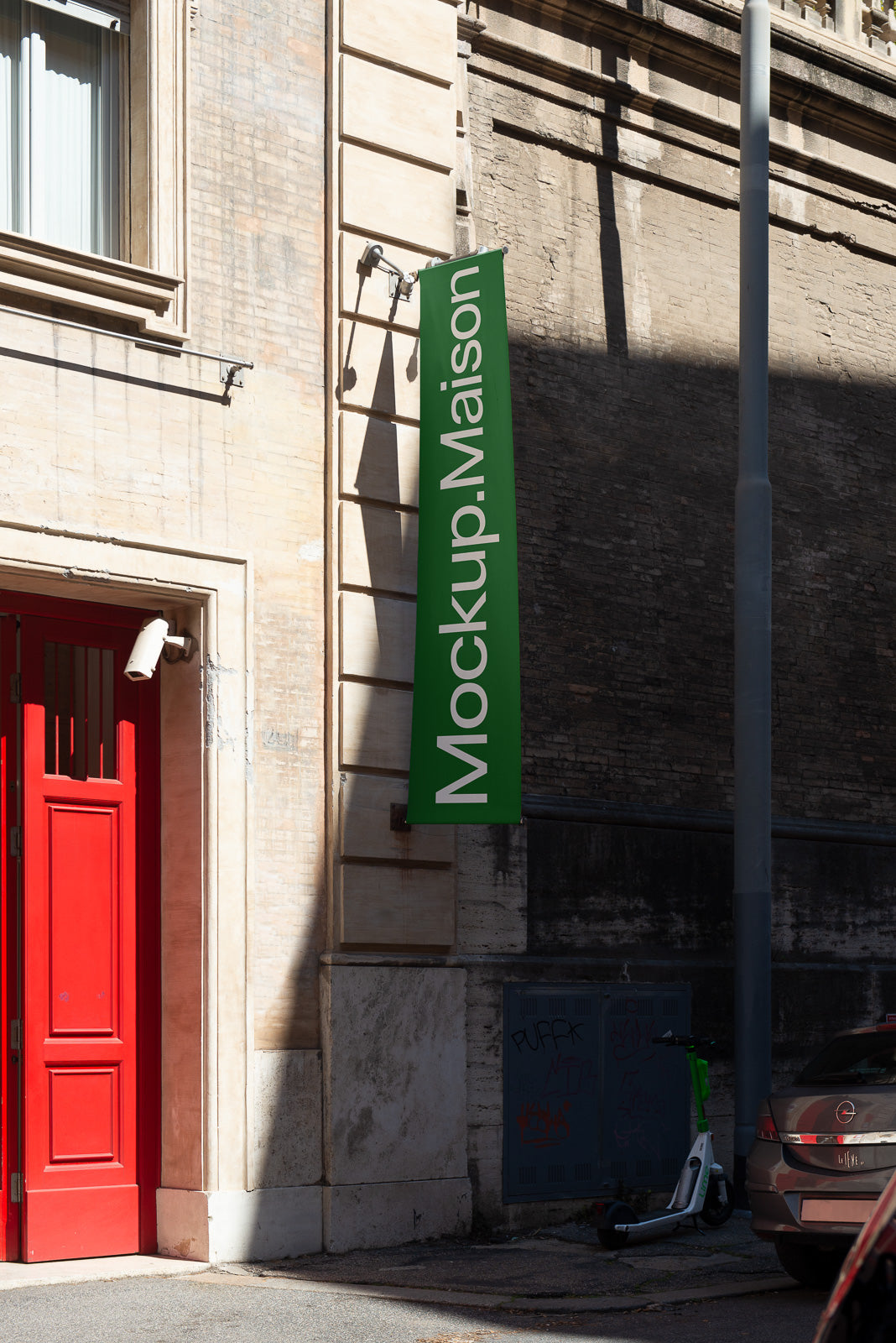 PSD mockup featuring a vertical green sign with white text "Mockup.Maison" on an urban building exterior next to a bright red door and parked scooter.