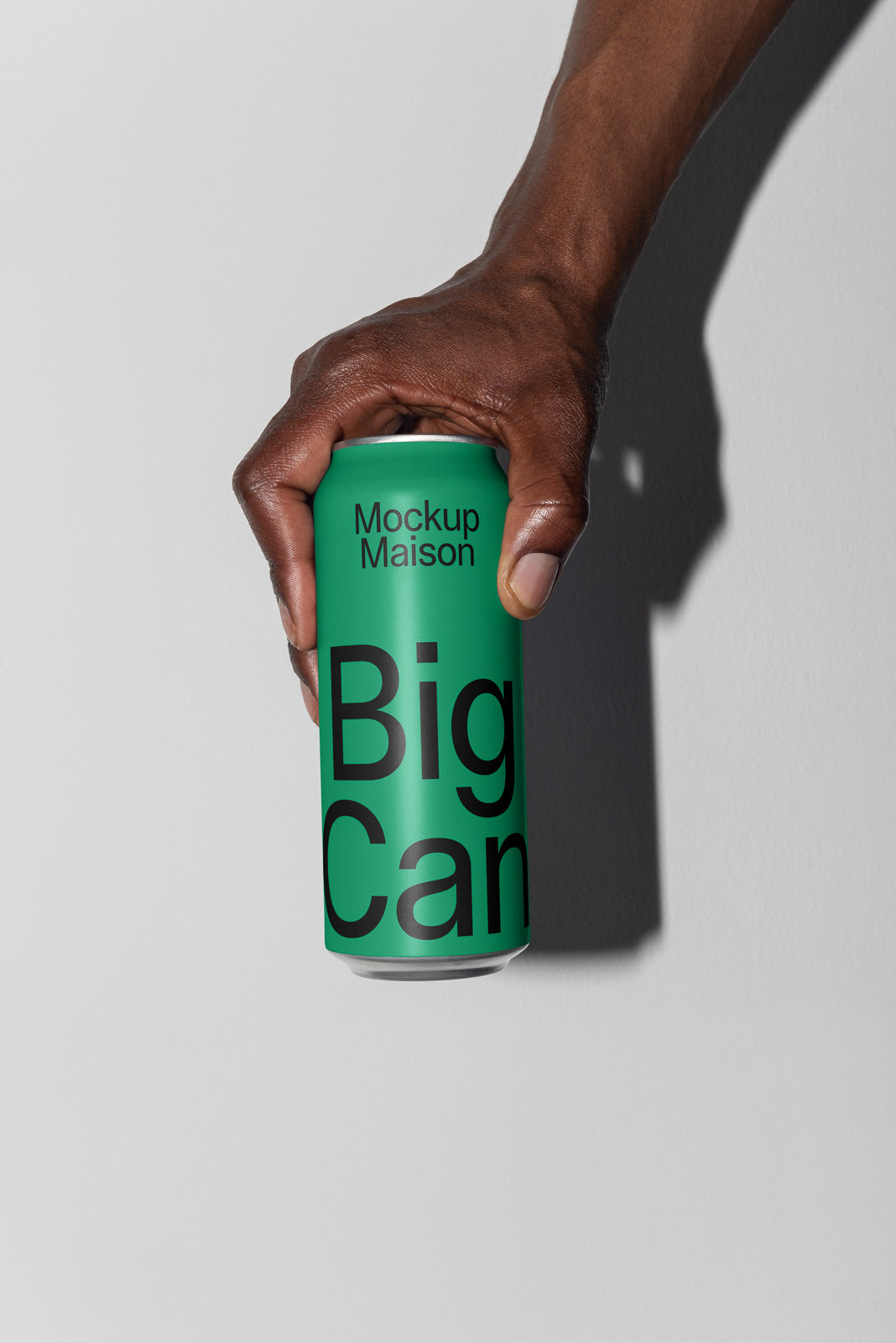 PSD mockup of a hand gripping a green can labeled "Mockup Maison Big Can" against a plain background.