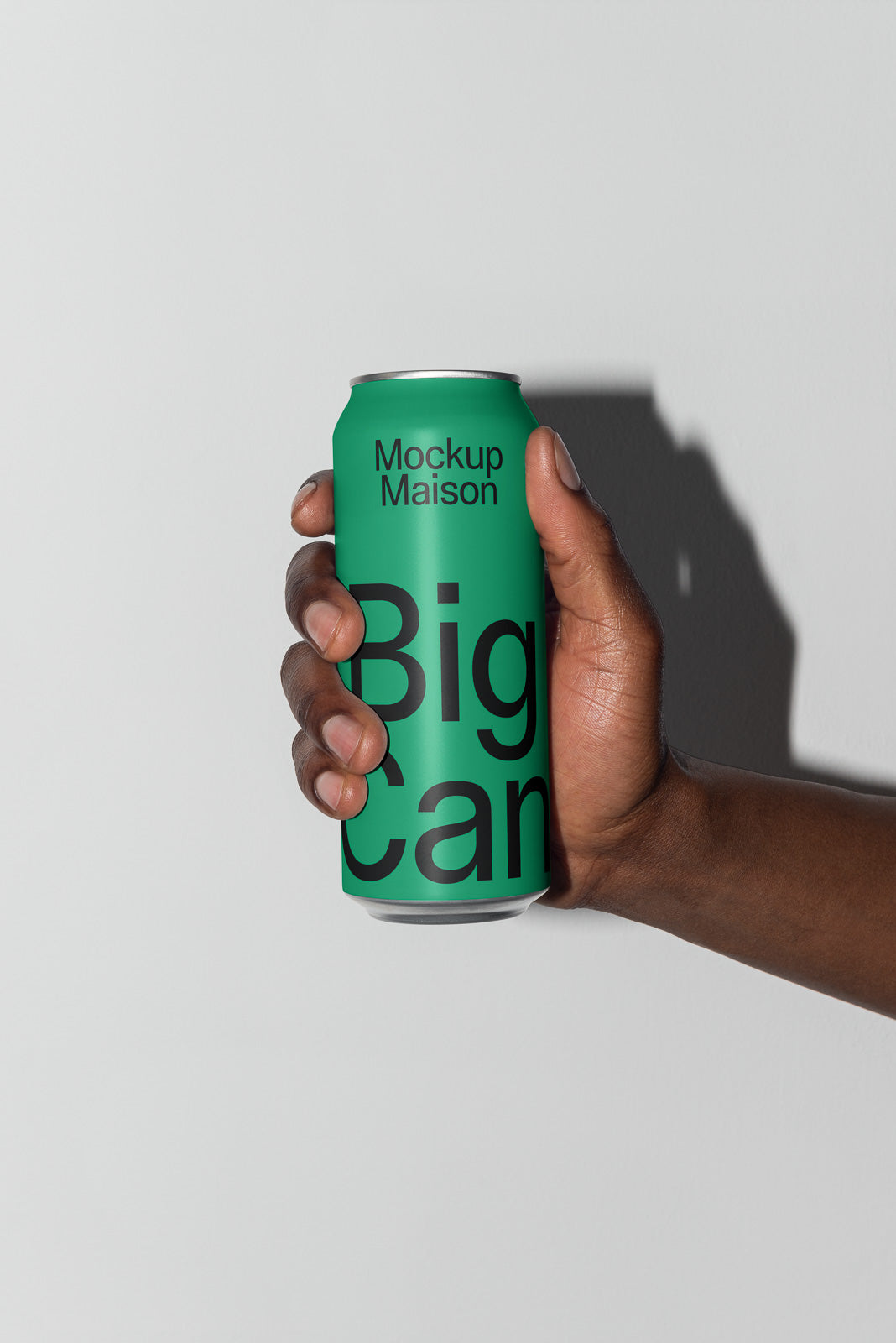PSD mockup of a hand holding a green can labeled "Mockup Maison Big Can" against a light gray background.