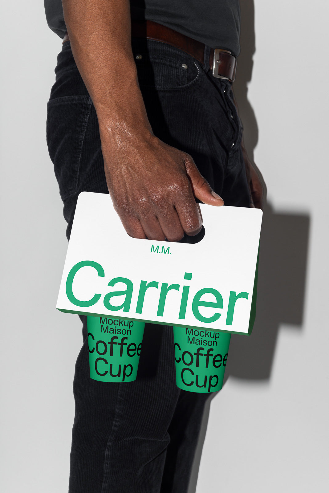 PSD mockup of a hand holding a branded cardboard carrier with two coffee cups labeled "Mockup Maison Coffee Cup" against a neutral background.