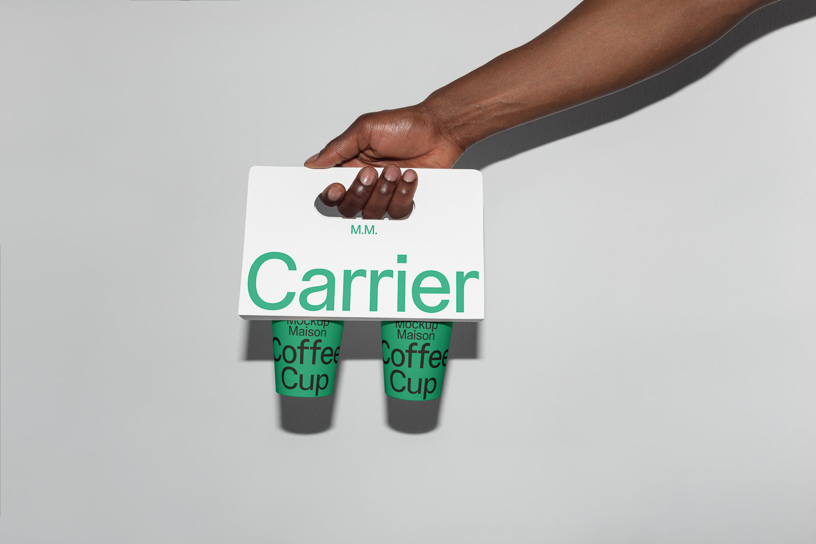 PSD mockup of a hand holding a white carrier with two green coffee cups partially visible underneath, against a neutral background.