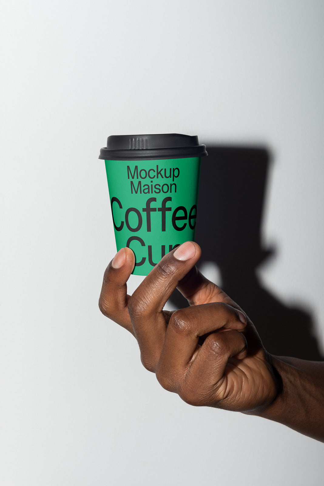 PSD mockup of a green coffee cup held by a hand, featuring the text "Mockup Maison Coffee Cup" in a minimalist style.