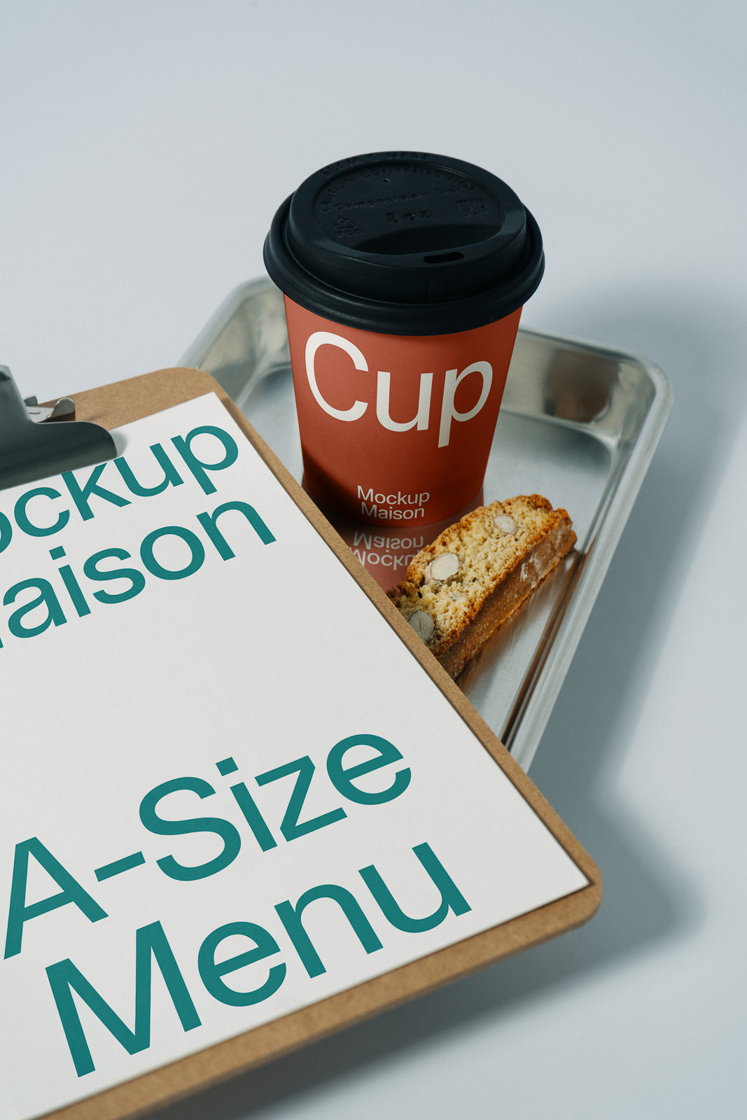 PSD mockup of a clipboard with an A-size menu next to a branded cup and biscotti on a tray, capturing a minimalist and modern design.