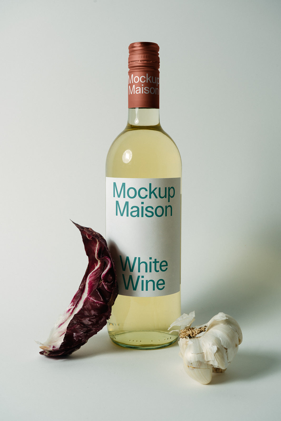 PSD mockup of a white wine bottle labeled "Mockup Maison" with radicchio leaf and garlic on a neutral background.