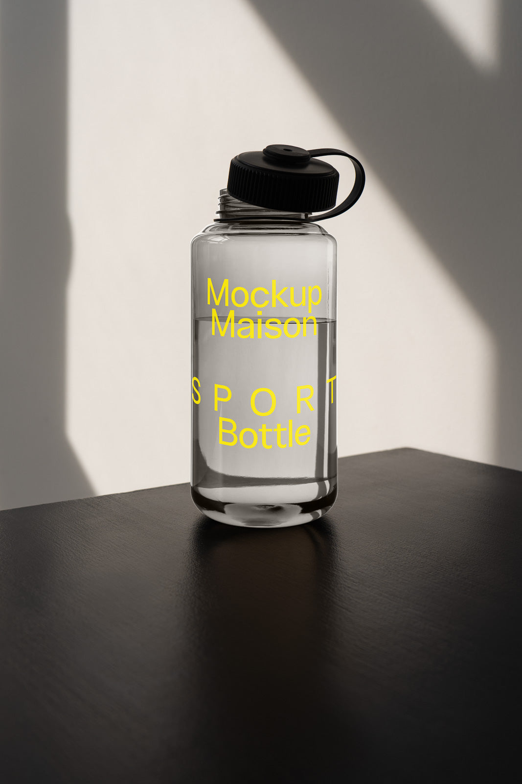 PSD mockup of a transparent sports water bottle with a black cap, showcasing the label "Mockup Maison SPORT Bottle" in yellow text.