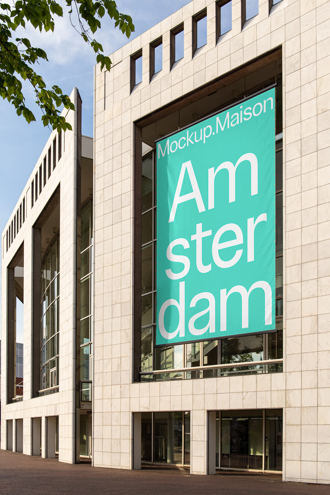 PSD mockup of a large teal banner on a modern building facade, displaying the text "Mockup.Maison Amsterdam" in bold white letters.