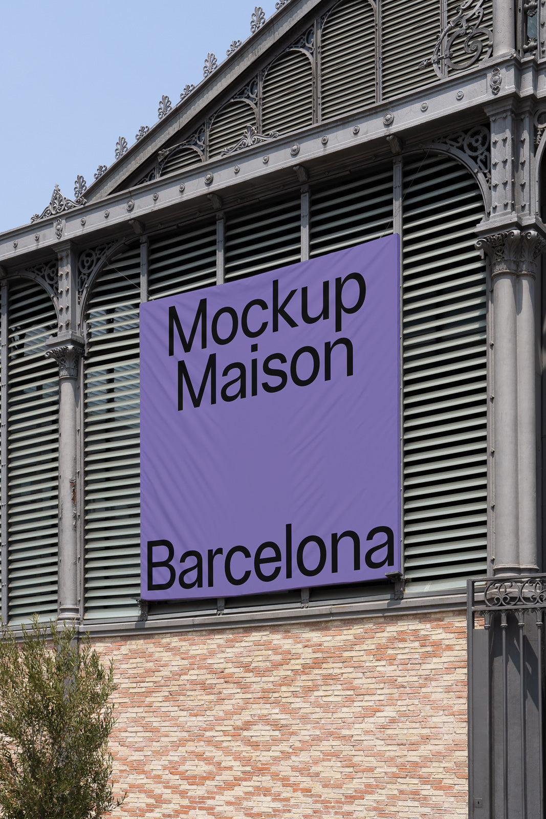 PSD mockup of a large purple banner on an ornate metal and brick building, featuring bold black text reading "Mockup Maison" and "Barcelona".