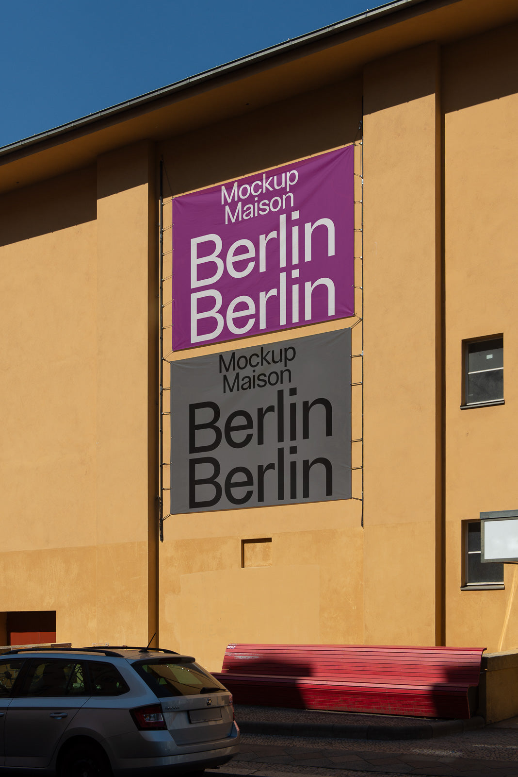 PSD mockup of banners hanging on a yellow building facade, displaying "Berlin" text in bold white and black fonts on purple and gray backgrounds.