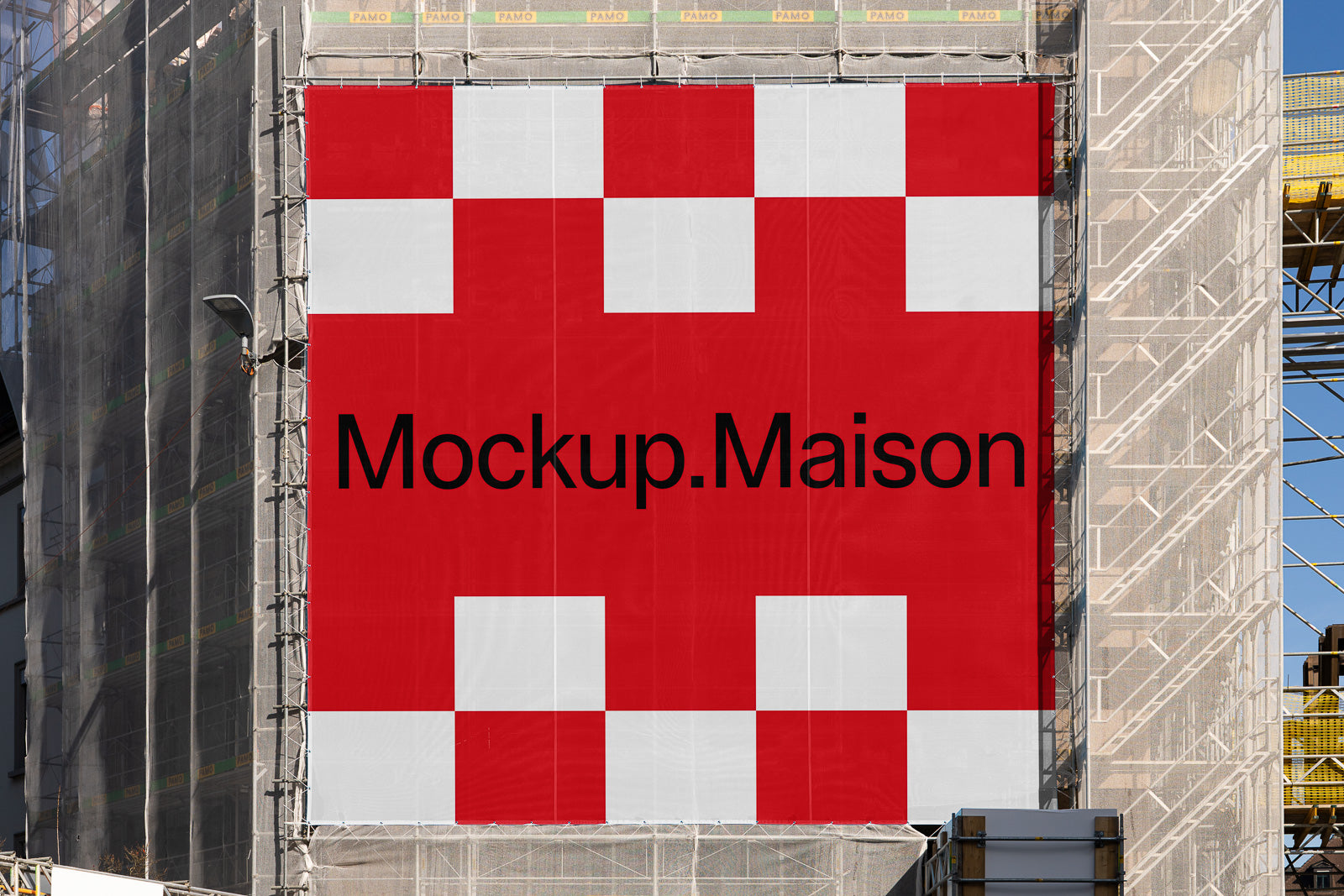 PSD mockup of a large outdoor banner on a building facade, displaying a red and white checkered pattern with the text "Mockup.Maison" in bold.
