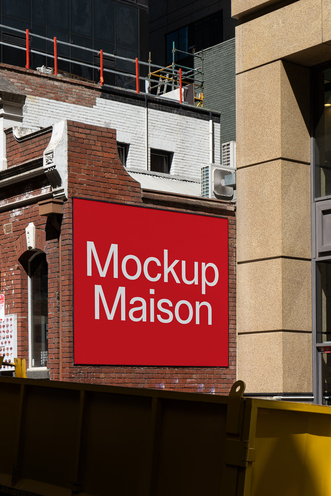 PSD mockup of a red outdoor wall sign on a brick building, showcasing "Mockup Maison" in bold white text.