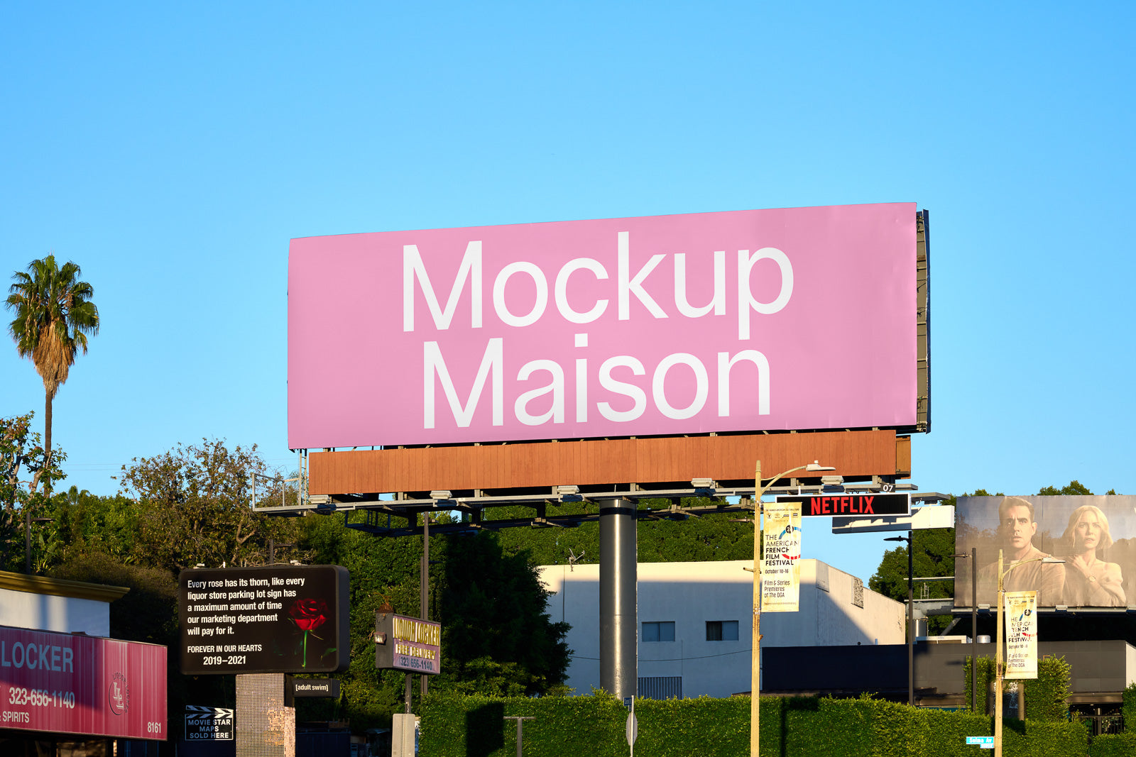 PSD mockup of a large outdoor billboard featuring a pink background and the text "Mockup Maison" in white, set against a clear blue sky.
