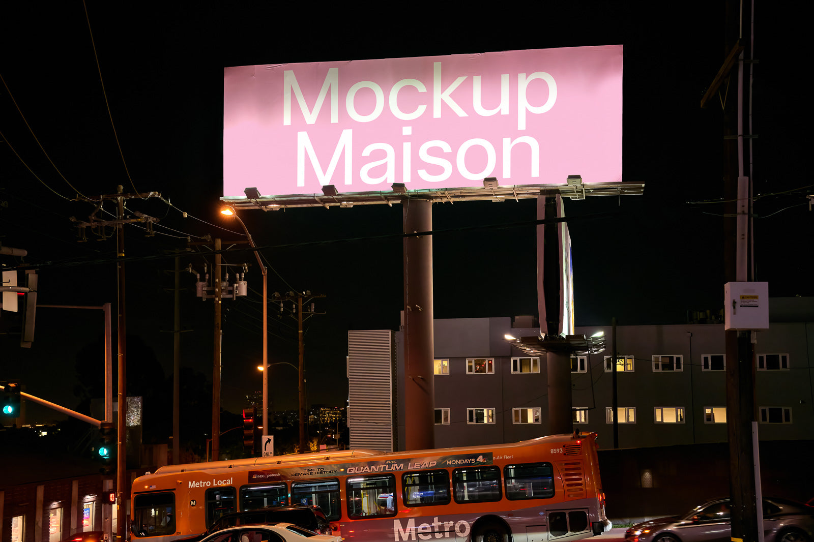 PSD mockup of a large roadside billboard at night, lit by surrounding streetlights and near city buildings, with a Metro bus passing below.