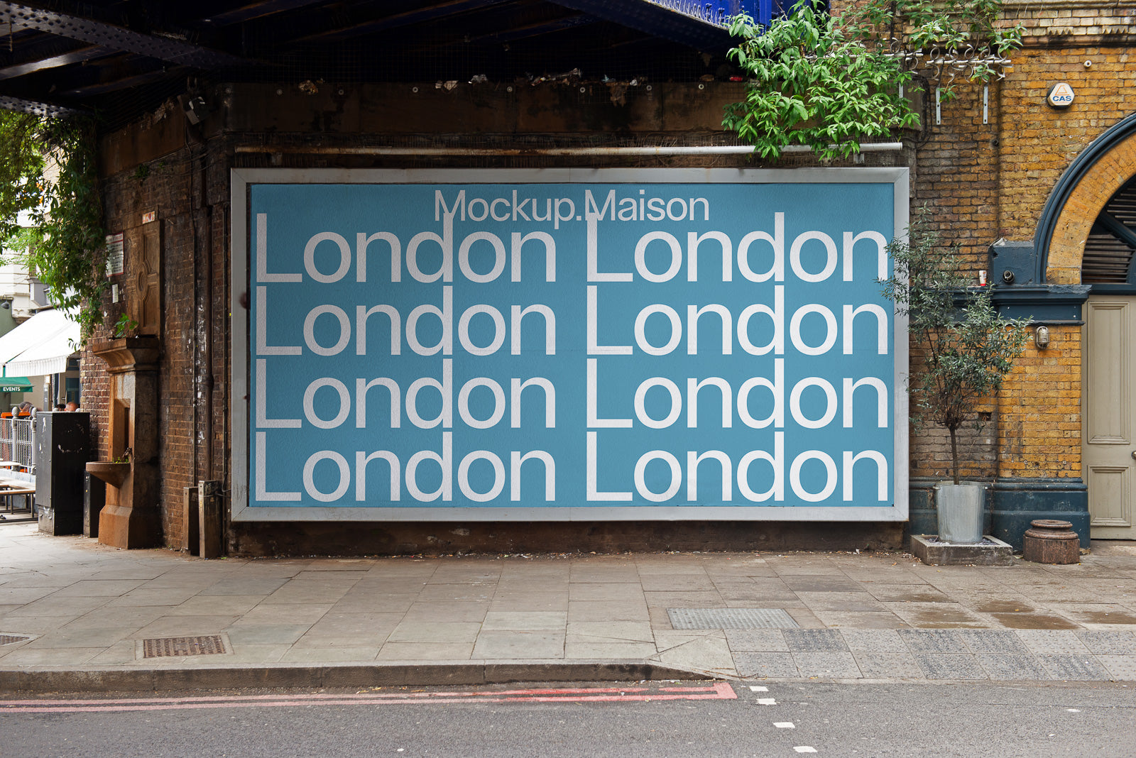 PSD mockup of a large billboard under a bridge featuring repetitive text "London" on a blue background against a brick wall in an urban setting.